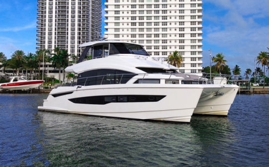 Luxury Aquila 54 power catamaran yacht rental cruising the waterways of Miami with waterfront skyline views at Dream Exotics Miami