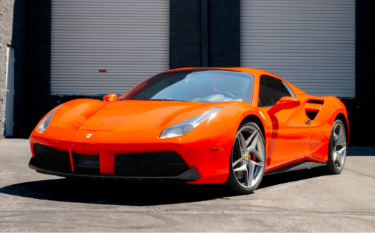 Red Ferrari 488 exotic car rental parked outside Dream Exotics Miami available for luxury driving experiences in Miami