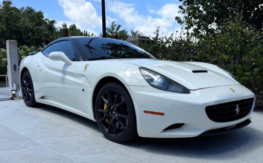 White Ferrari California convertible luxury rental with black wheels parked outdoors at Dream Exotics Miami in South Florida